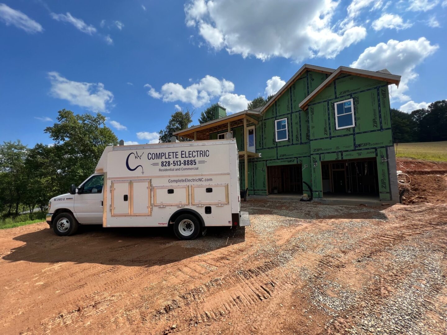 A white truck parked in front of a green house.